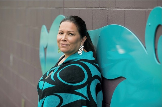 q̓ʷɑti̓cɑ / Phyllis Atkins next to her public artwork A Bear’s Feast (sƛ̓ənəqs kʷə speʔəθ) in civic collection of City of Maple Ridge. Photo by Oliver Rathonyi-Reusz.