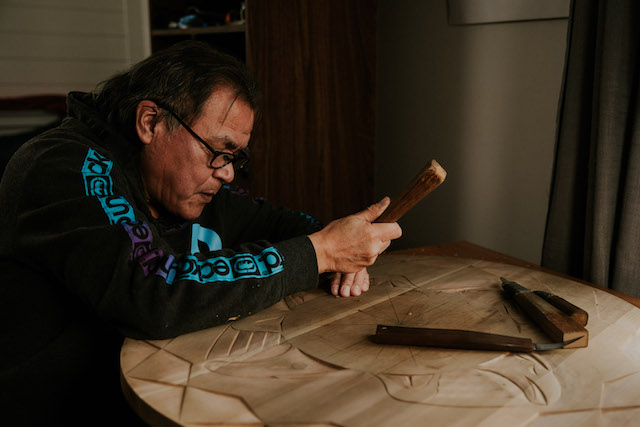 Nuu-chah-nulth Artist Patrick Amos of the Mowachaht Band working on a cedar carving