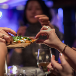 Group enjoying pizza and glass of wine for Dine Out Vancouver