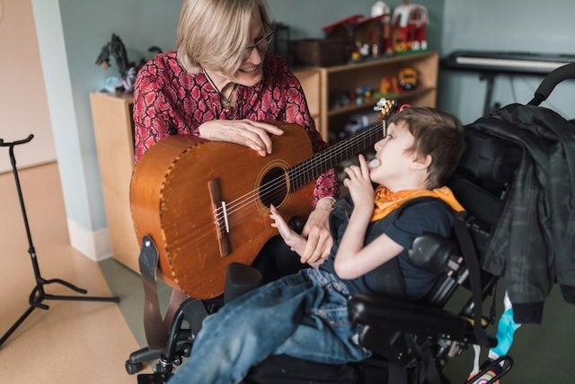 Photo caption: Karin Roberts, Canuck Place Music Therapist, with Owen Hill-Davie, Canuck Place Child