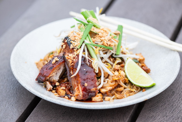 Sen Pad Thai's noodle dish with BBQ ribs, lime, garnishes and chopsticks on their patio