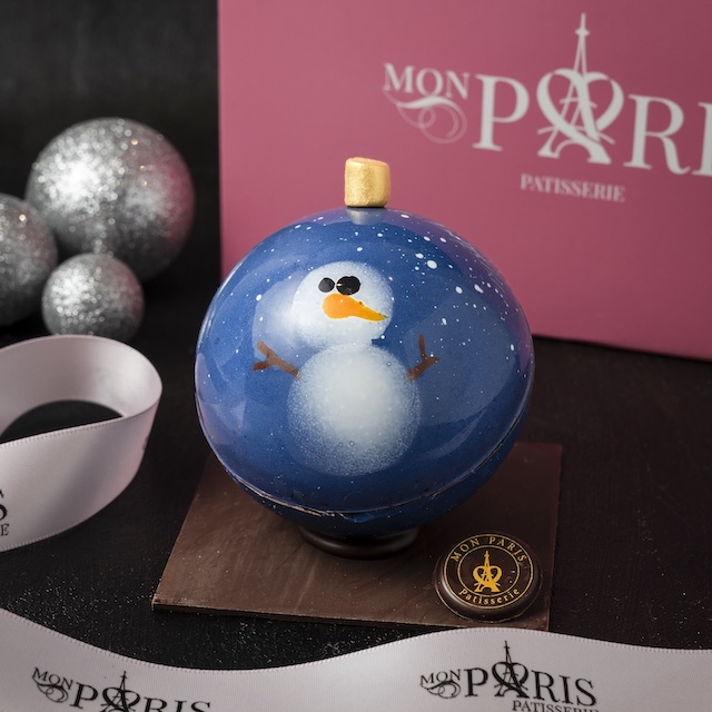 Milk chocolate ornament with a blue backdrop and a snowman on it from Mon Paris