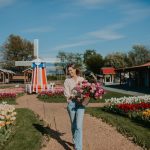 Woman picking flowers at Greendale Acres for Mother's Day by windmill
